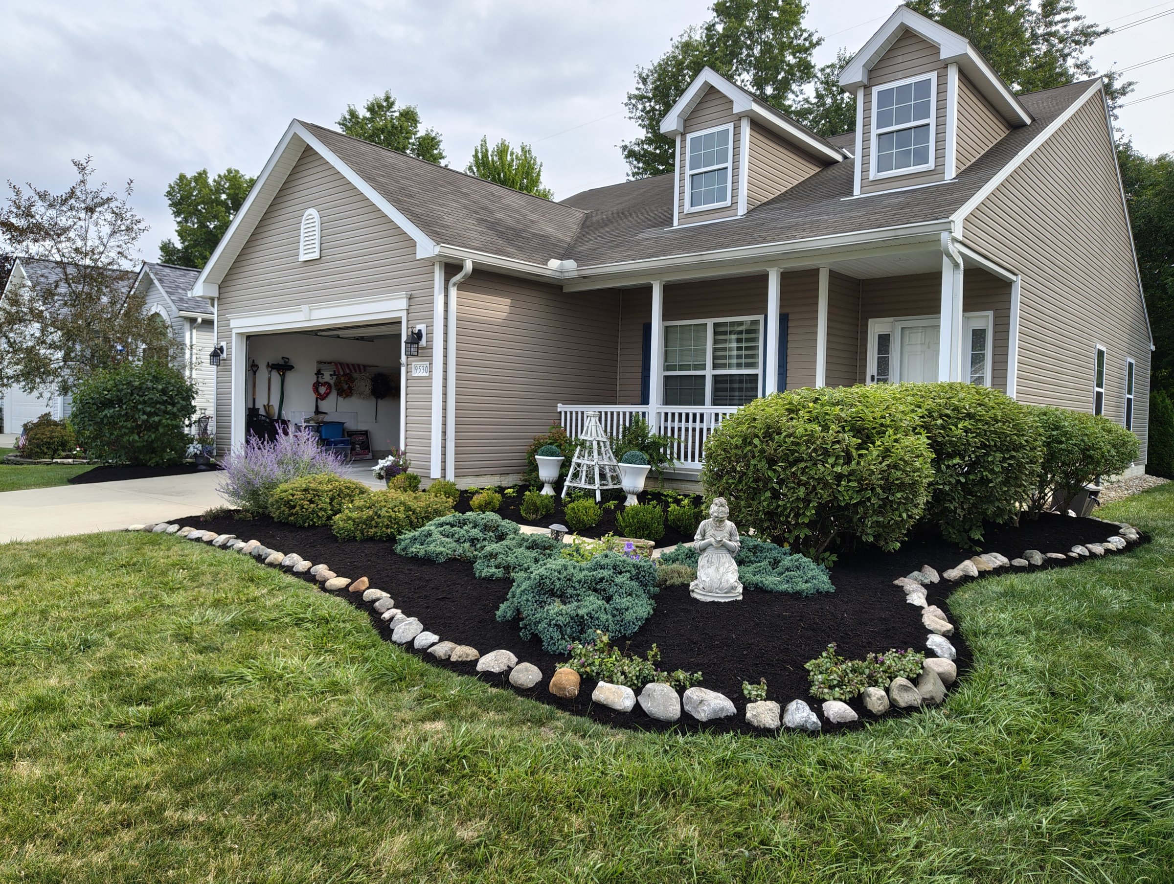 Front yard landscape bed with stone border and mulch